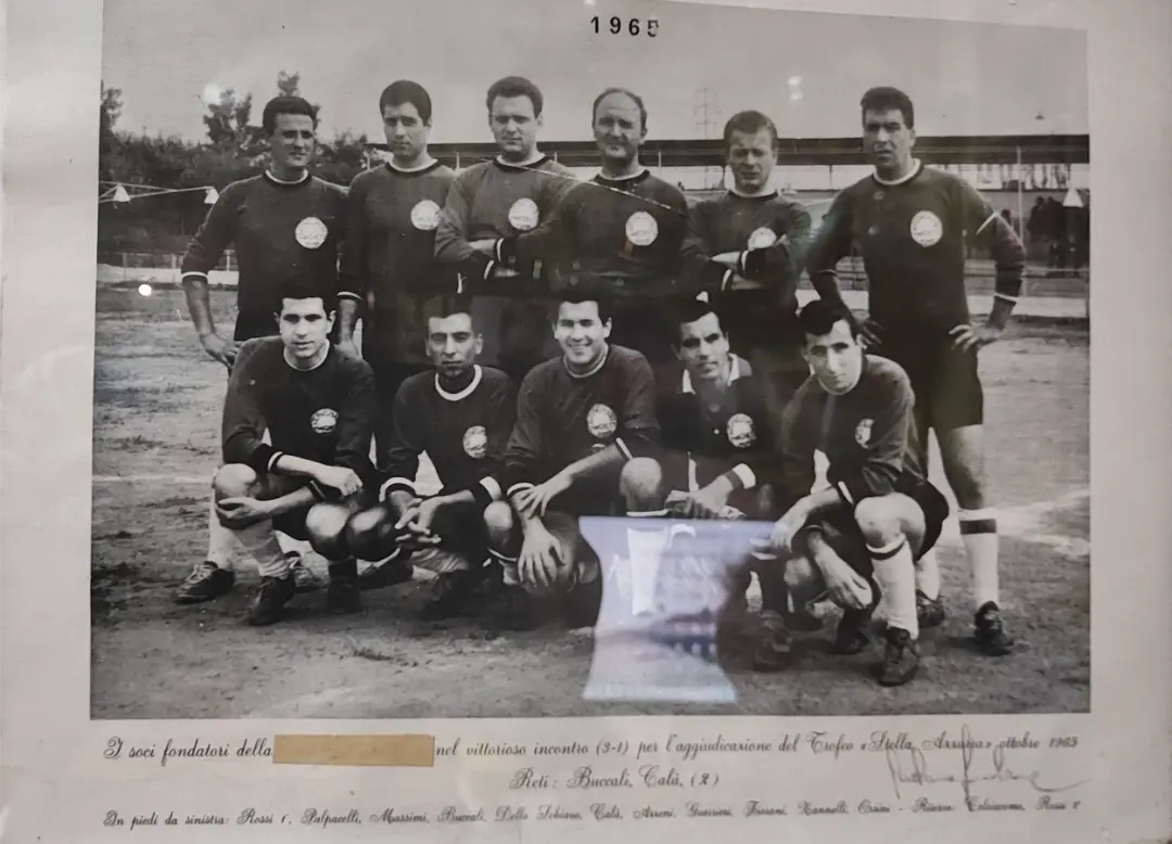 Fotografia in bianco e nero del 1965 con un gruppo di calciatori della squadra delle origini della Polisportiva Pian Due Torri, in posa sul campo da calcio.